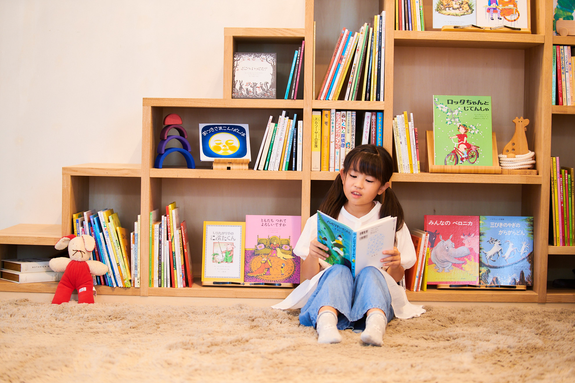 本棚の前で絵本を読む子ども